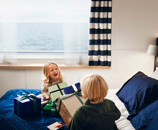 Barn sitter bland julklappar i sängen